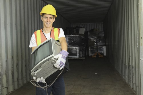 Worker wearing PPE preparing to remove garden waste